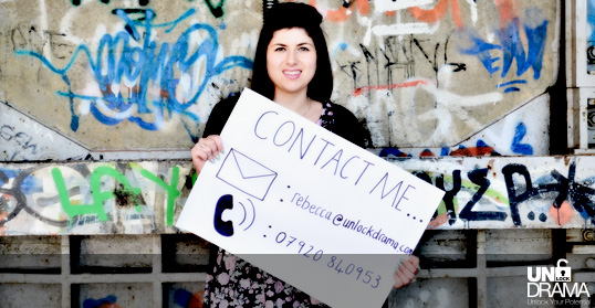 Rebecca holding a sign with the contact details to get in touch about an Unlock drama project in your prison or community